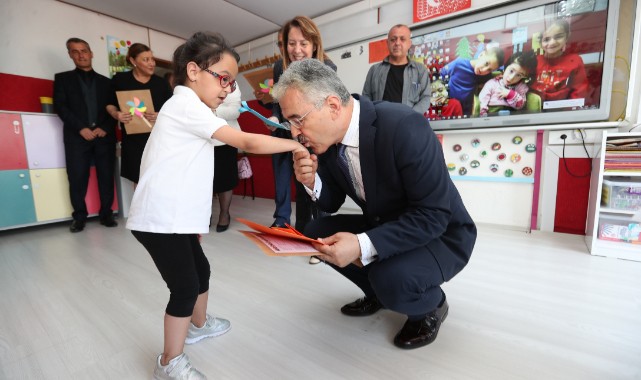 Vali işitme engelli öğrencinin elini öperek karnesini verdi